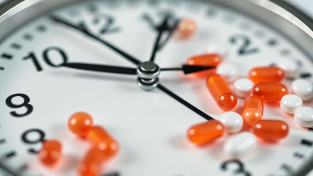 A close-up image of a clock with tadalafil pills scattered around, symbolizing the timing and duration of the medication's effects.